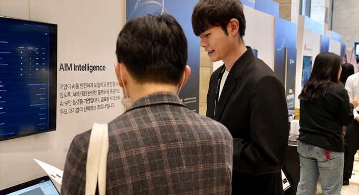 베스핀글로벌 AI 파트너스데이 컨퍼런스 부스에서 담당자가 방문객에게 AI 관련 솔루션을 설명하고 있는 모습이다.